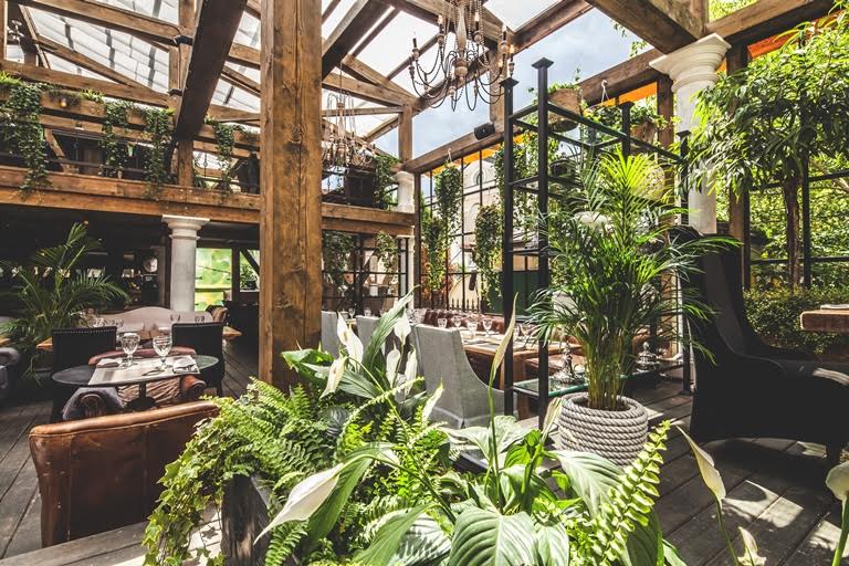 Летняя веранда ресторана Modus - деревянный интерьер с растениями