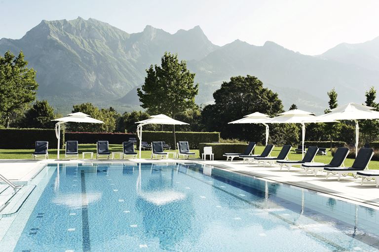 Курорт Grand Resort Bad Ragaz в Швейцарии - открытый бассейн отеля с видом на горы 