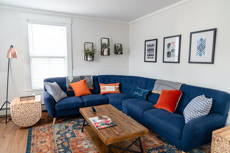 Сочетание цветов в интерьере - тёмно-синий диван в комнате со светлыми стенами