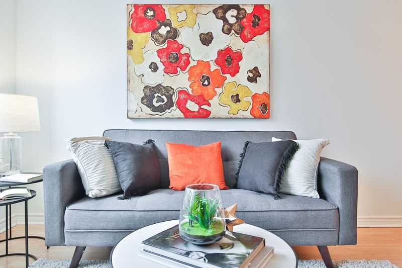 Сочетание цветов в интерьере - серый диван в интерьере с оранжевыми акцентами