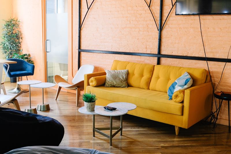 Яркие оттенки в интерьере - жёлтый диван и оранжевая стена